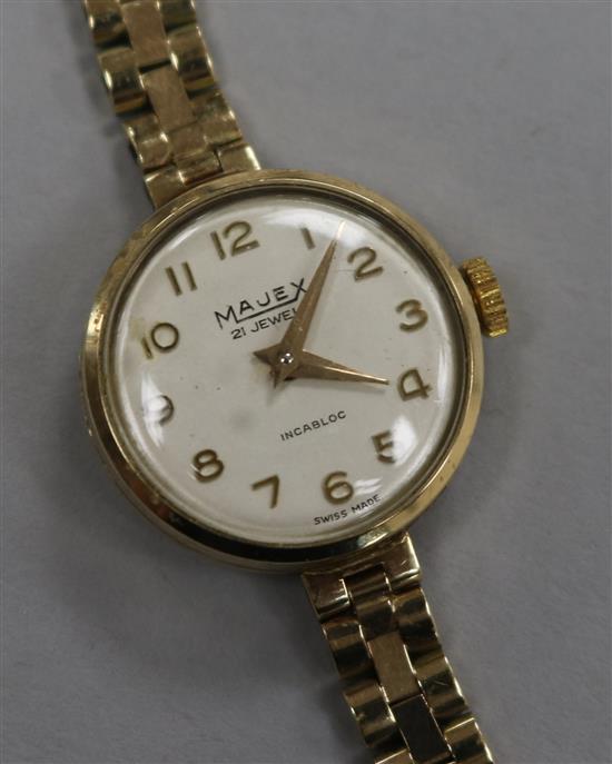 A ladys 9ct gold Majex manual wind wrist watch on a 9ct gold bracelet.